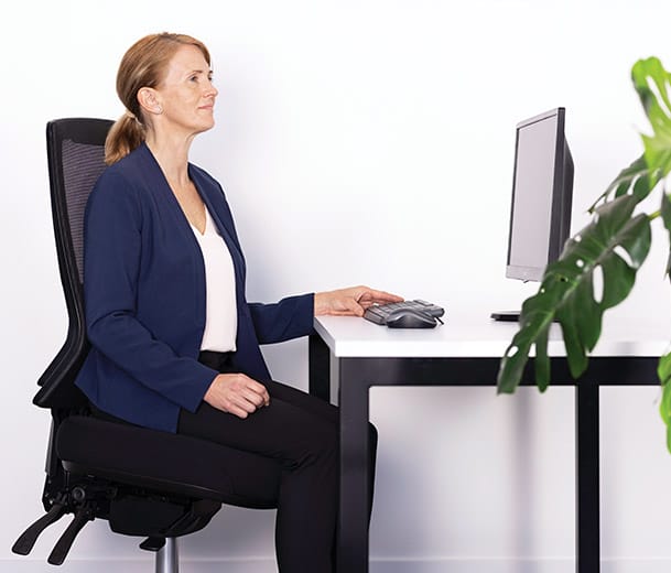 Woman seated at a desk on a Buro Metro II 24/7 High Back ergonomic chair