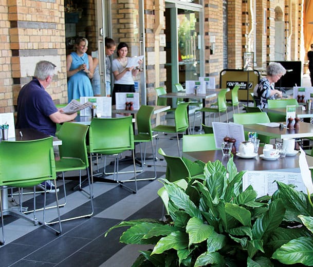 Green Buro Envy chairs in outdoor cafe scene with brick walls