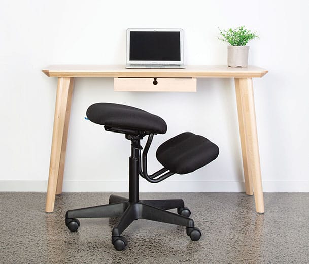 Buro Knee ergonomic chair next to desk in home office scene