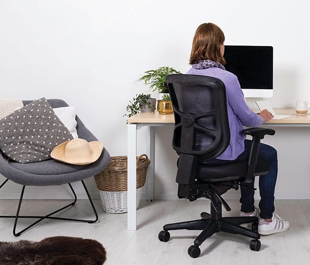 Woman seated on a Buro Metro chair in a home office scene