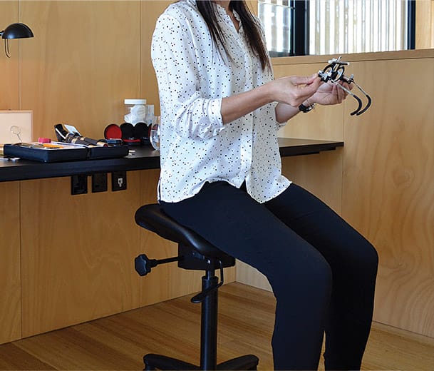 Woman seated on a Buro Posturite stool in optometrist clinic