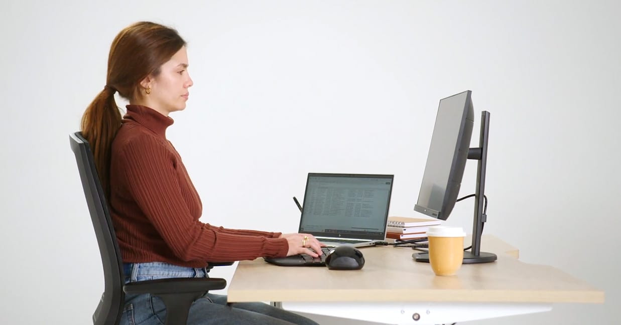 Lady sitting at desk that is the wrong height