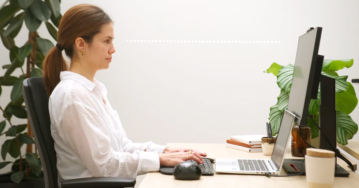 Woman at desk showing correct monitor positioning