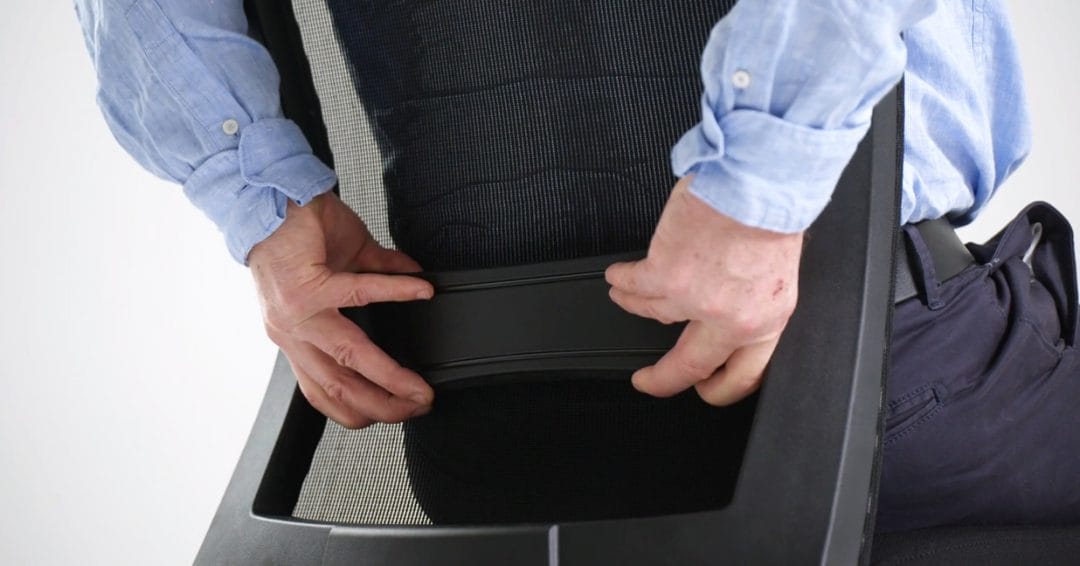Man adjusting lumbar on back of black office chair
