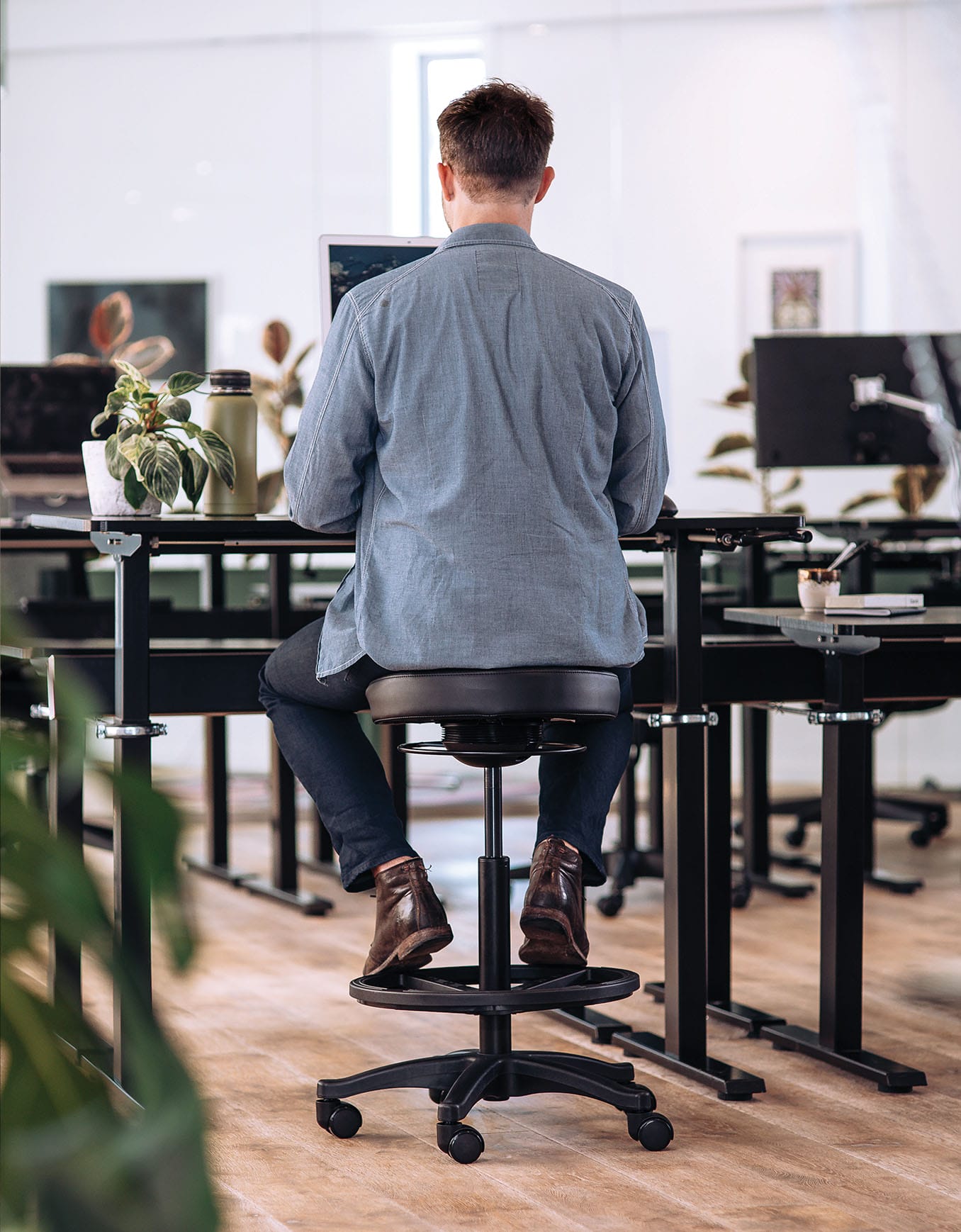 man sitting at workstation on stool