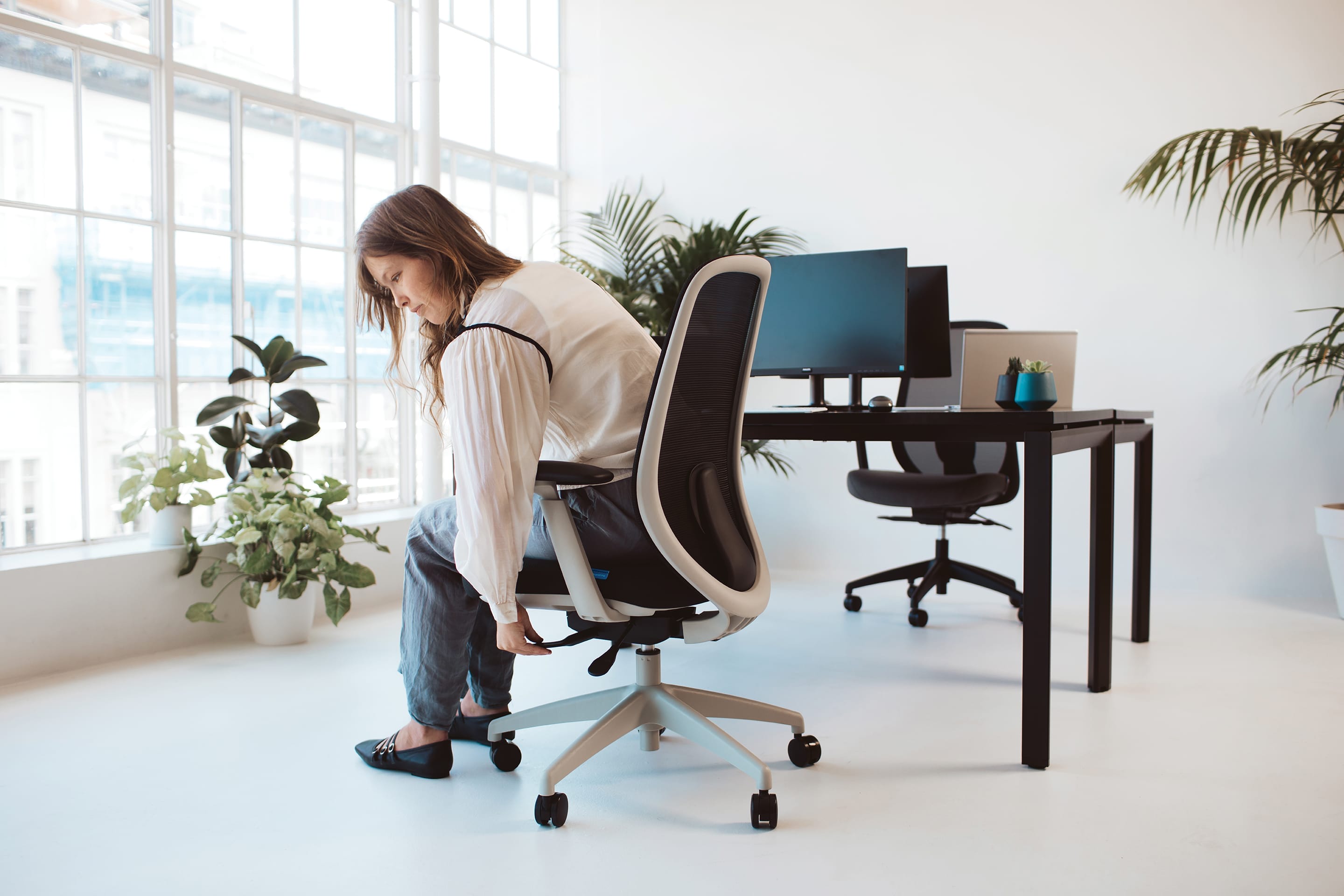 woman adjusts her buro force ergonomic chair